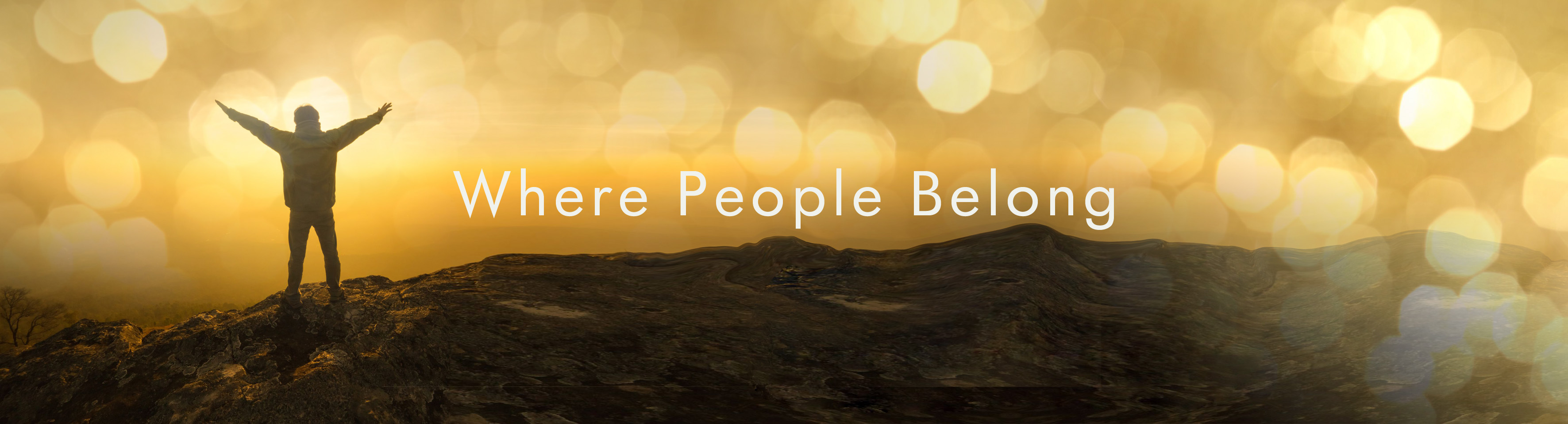 Person with arms outstretched on a hilltop at sunrise — Where People Belong